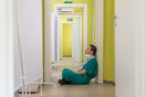 Κουρασμένοι νοσοκόμα κάθεται στο πάτωμα