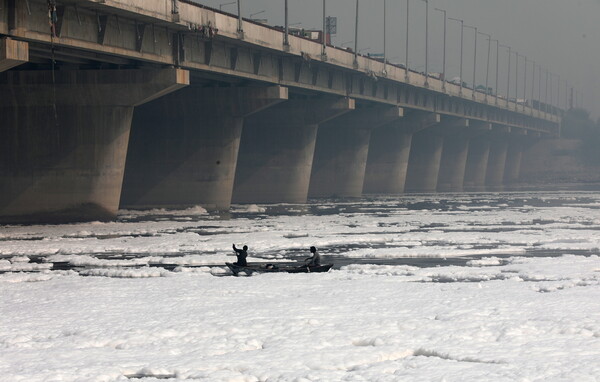 Toxic foam coats sacred river in India as Hindu devotees bathe in its waters