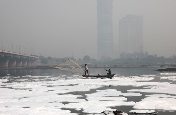 Toxic foam coats sacred river in India as Hindu devotees bathe in its waters