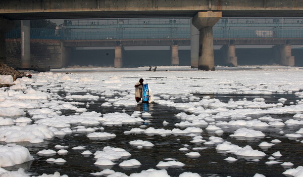 Toxic foam coats sacred river in India as Hindu devotees bathe in its waters