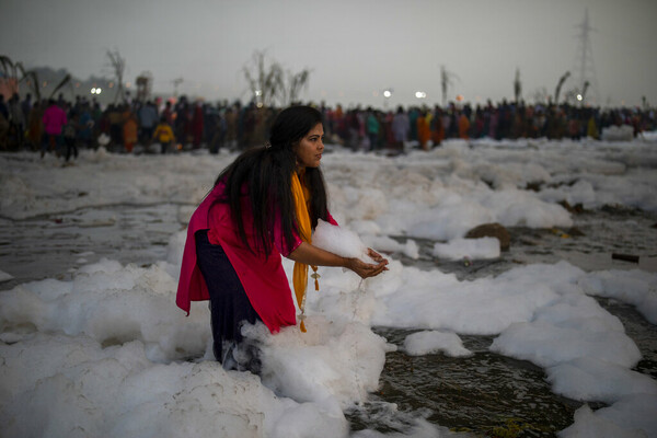 Toxic foam coats sacred river in India as Hindu devotees bathe in its waters