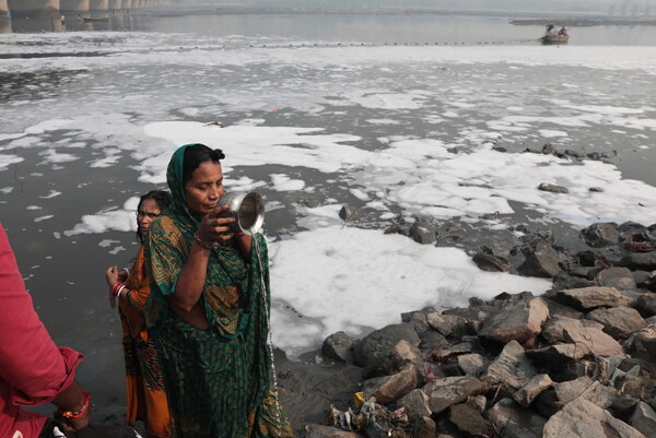 Toxic foam coats sacred river in India as Hindu devotees bathe in its waters