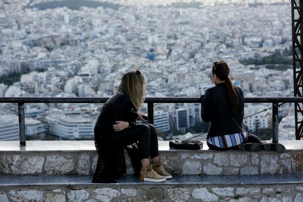 Δύο γυναίκες κάθονται σε πεζούλι