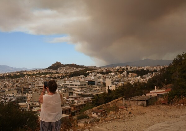 Ο καπνός της φωτιάς στον Βαρνάβα κάνει απόκοσμο τον ουρανό της Αττικής