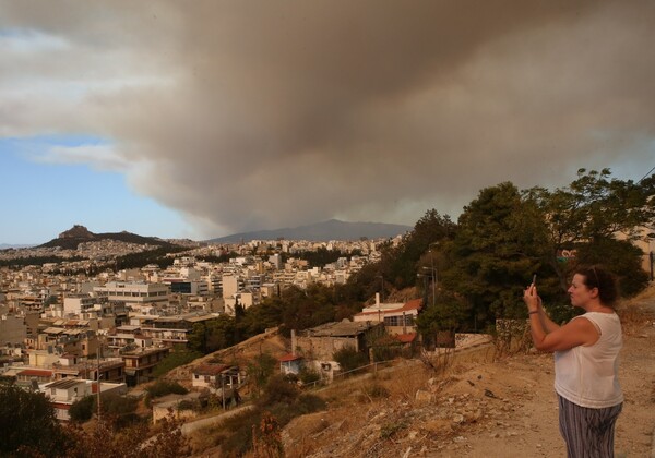 Ο καπνός της φωτιάς στον Βαρνάβα κάνει απόκοσμο τον ουρανό της Αττικής