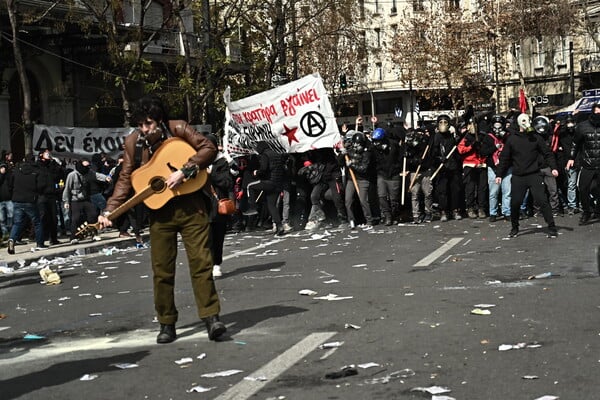 Πορεία για τα Τέμπη στην Αθήνα: Μουσικός με την κιθάρα του δίπλα από τα ΜΑΤ την ώρα των επεισοδίων